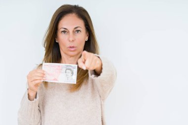50 pound banknot tutan orta yaş kadın kamera ve size parmak ile işaret arka plan izole, el işareti, pozitif ve kendinden emin bir jest ön