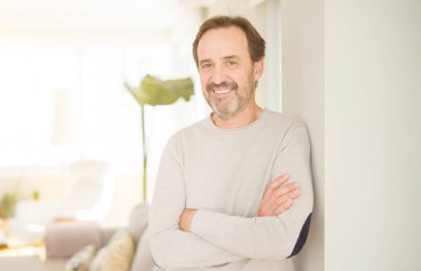 Evde kameraya bakarak gülümseyen yakışıklı orta yaş erkek