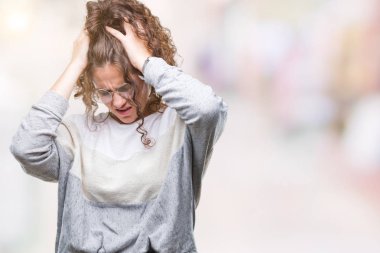 Güzel esmer kıvırcık saçlı Genç kız gözlüklü çünkü umutsuz ve stresli baş ağrısı acı izole arka plan üzerinde ağrı ve migren. Ellerini kafasına.