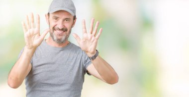 Yakışıklı orta yaş ağarmış komuta sizde Spor şapkası üzerinde gösterilen arka plan izole ve parmakları ile işaret kendinden emin ve mutlu gülümseyerek süre on numara.