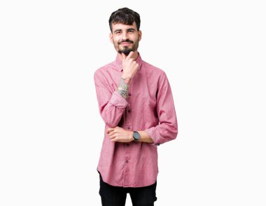 Emin çapraz kollar ve çeneme kaldırdı el ile gülümseme ile kameraya bakarak izole arka plan üzerinde pembe gömlek giymiş yakışıklı delikanlı. Pozitif düşünce.