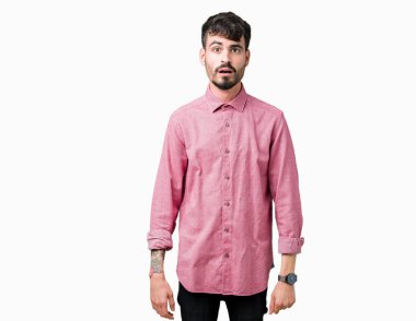 Yakışıklı delikanlı korkuyor ve şok sürpriz ifade, korku ve heyecan yüz ile izole arka plan üzerinde pembe gömlek giymiş.