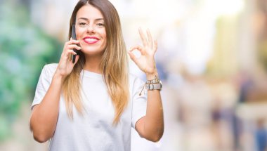 Genç güzel kadın konuşma arama Smartphone parmak, mükemmel sembolü ile ok işareti yapıyor izole arka plan üzerinde kullanma