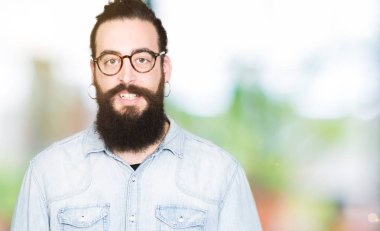 Genç hipster adam uzun saçlı ve gözlüklü mutlu ve güzel bir gülümseme ile yüzünde sakal. Şanslı kişi.