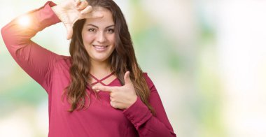 Artı boyutu genç kadın elle yapma çerçeve ve parmakları ile mutlu yüz gülümseyen izole arka plan güzel. Yaratıcılık ve Fotoğrafçılık kavramı.