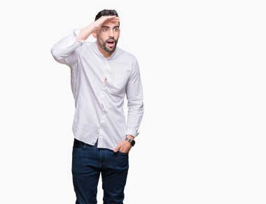 Genç iş adamı izole arka plan çok mutlu ve gülümseyen uzakta el ile üzerine kafa seyir üzerinde. Arama kavramı.