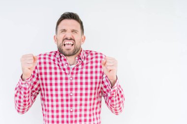 Yakışıklı delikanlı izole arka kolları olan başarı için heyecan üzerinde gömlek giymiş zafer kutluyor gülümseyen kaldırdı. Kazanan kavramı.