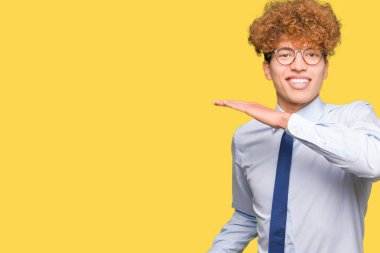 Genç yakışıklı iş adamı ile eller eller büyük gösterilen ve büyük boy işareti, ölçü birimi sembolü ile gözlüklü afro. Kameraya bakarak gülümsüyordu. Ölçüm kavramı.