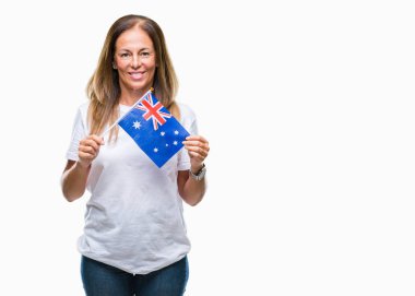 Avustralya bayrağı izole arka plan üzerinde duran ve diş gösterilen kendine güvenen bir gülümsemeyle gülümseyerek mutlu bir yüz tutan orta yaş İspanyol kadın