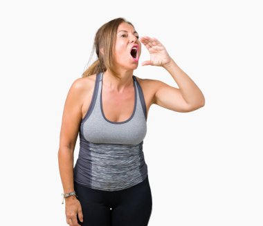 Bağırarak ve ağzı üzerinde el ile yan için çığlık izole arka plan üzerinde spor kıyafet giyen güzel orta yaş kadın. İletişim kavramı.