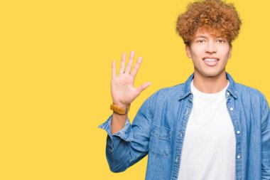 Gösterilen ve parmakları ile işaret denim ceket giyen afro saçlı Genç yakışıklı adam kendinden emin ve mutlu gülümseyerek süre beş numara.