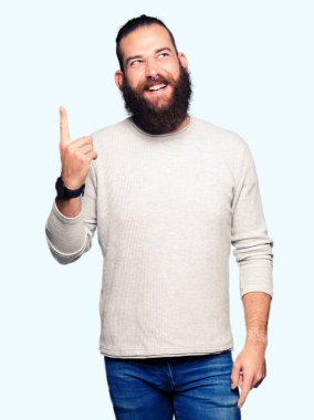 Genç Sarışın başarılı fikirle giyen sıradan kazak işaret parmağı adam. Çıktıktan ve mutlu. Bir numara.