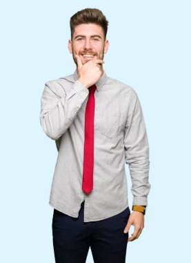 Genç yakışıklı iş adamı emin çapraz kollar ve çeneme kaldırdı el ile gülümseme ile kameraya bakıyor. Pozitif düşünce.