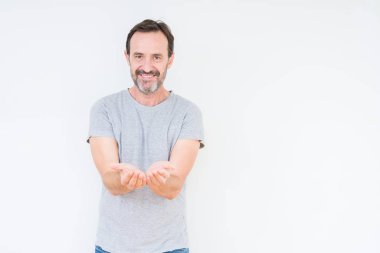 İzole arka plan üzerinde üst düzey yakışıklı gülen ellerle birlikte alma veya jest vererek palms. Ayrı tutma ve koruma