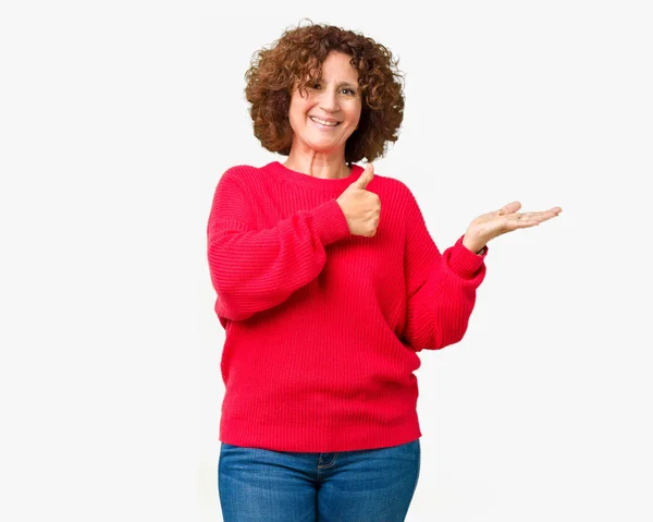 美丽的中间年龄的老年妇女红色冬天毛衣在孤立的背景显示手掌手和做确定的手势与竖起大拇指 微笑快乐和欢快 — 图库照片