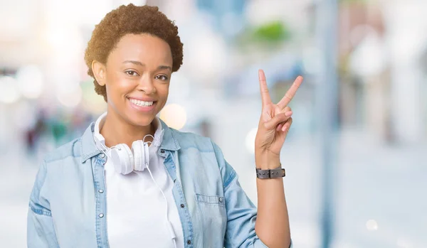 Mujer Afroamericana Joven Con Auriculares Sobre Fondo Aislado Sonriendo Con —  Fotos de Stock