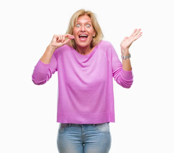 Mujer Rubia Mediana Edad Comiendo Galleta Macaron Rosa Sobre Fondo — Foto de Stock