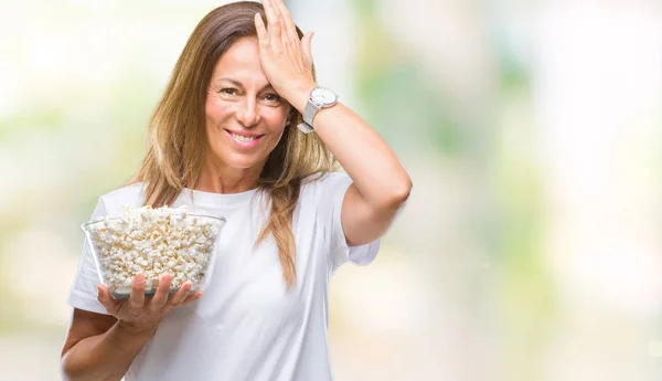 中年西班牙妇女吃爆米花在孤立的背景下 用手在头上强调 震惊与羞愧和惊讶的脸 愤怒和沮丧 因错误而恐惧和不安 — 图库照片