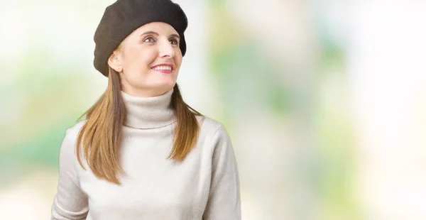 中年成熟的女人穿着冬衣和贝雷帽在孤立的背景看着一边面带微笑 自然的表情 笑自信 — 图库照片