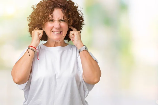 騒々しい音楽のノイズの腹が立つ式の指を使って耳をカバー分離の背景に白い シャツを着て美しい中間エイガー年配の女性 聴覚障害者の概念 — ストック写真