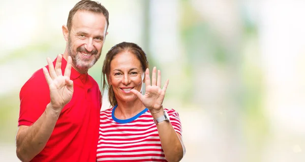 中年西班牙夫妇在爱在孤立的背景显示和指着9号手指 同时微笑着自信和快乐 — 图库照片