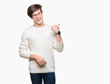 Seyir ve başparmak yanında yukarıyı mutlu yüz ile gülümseyen izole arka plan üzerinde gözlük takan genç yakışıklı adam.