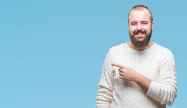 İzole arka neşeli bir gülümseme ile el ve parmak kadar kameraya bakarak yüzündeki mutlu ve doğal ifade ile yan ile işaret yüz üzerinden kış kazak giyen genç beyaz hipster adam.