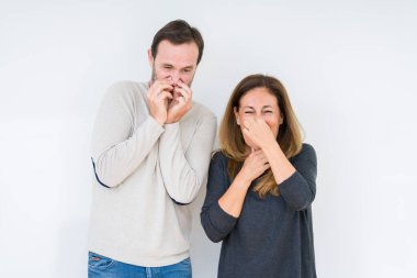 Güzel orta yaş kaç aşk bir şey pis ve iğrenç kokulu izole arka plan, dayanılmaz koku, holding nefes burun parmaklar ile içinde. Kötü kokuyor kavramı.