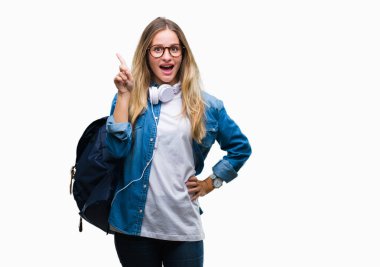 Kulaklık ve gözlük izole arka plan üzerinde işaret parmağı kadar başarılı fikirle giyen genç güzel sarışın öğrenci kadın. Çıktıktan ve mutlu. Bir numara.