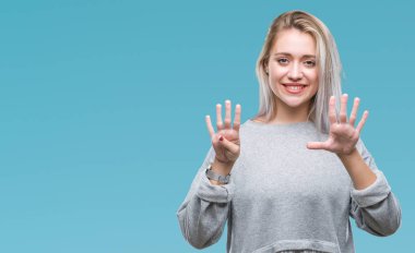 Sarışın genç kadın gösterilen ve parmakları ile işaret izole arka plan üzerinde numara 9 kendinden emin ve mutlu gülümseyerek süre.