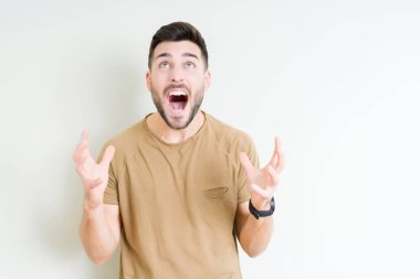 Genç yakışıklı adam izole arka plan çılgın ve kızgın bağırarak ve agresif ifade ve silah kaldırdı bağırıyor. Hayal kırıklığı kavramı.