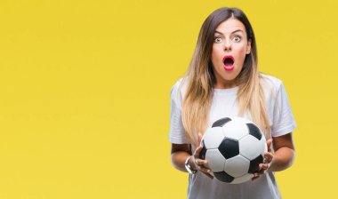 Futbol topu izole arka plan üzerinde bir sürpriz yüz, korkuyor ve heyecanlı korku ifadesi ile şok korkmuş tutan genç güzel kadın