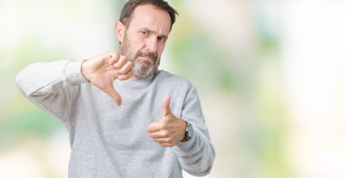 Yakışıklı orta yaş komuta sizde izole arka plan yapmaya başparmak üzerinde yukarı ve aşağı bir kazak giyiyor, anlaşmazlık ve anlaşma ifade. Deli çatışma