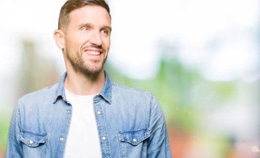 Denim ceket uzak tarafına gülümseme ile yüzünde, doğal ifade arıyorum giyen sakal ve mavi gözlü yakışıklı adam. Kendine güvenen gülüyor.