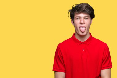 Genç yakışıklı dilini izole arka plan üzerinde kırmızı t-shirt giyen adam out komik ifade ile mutlu. Duygu kavramı.