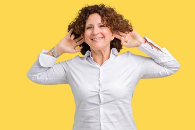 Güzel orta ager üst düzey businees izole arka plan gülen çekerek kulakları ile parmak, komik jest kadın. Seçmelere sorun