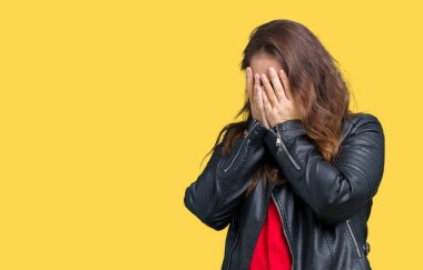 Artı boyutu genç kadın ağlayarak süre elleriyle yüzünü kapsayan üzgün ifade ile izole arka plan üzerinde bir moda deri ceket giymiş güzel. Depresyon kavramı.