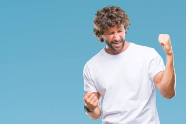 Gülümseyen ve başarı için çığlık yakışıklı İspanyol modeli izole arka plan çok mutlu ve heyecanlı kaldırdı, silah ile kazanan jest yapıyor adam. Kutlama kavramı.