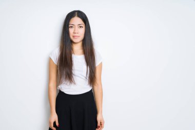 Yüzünde ciddi bir ifade ile izole arka plan güzel esmer kadın. Basit ve doğal kameraya bakıyor.