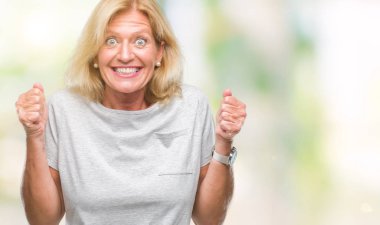 Orta yaş sarışın kadın izole arka kolları olan başarı için heyecan üzerinde zafer kutluyor gülümseyen kaldırdı. Kazanan kavramı.