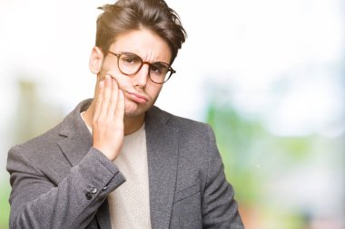 Diş ağrısı veya dişlerde dişlerle ilgili hastalık nedeniyle ağız acı ifadesi ile el ile dokunmak izole arka plan üzerinde gözlük takan genç iş adamı. Diş hekimi kavramı.