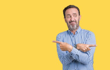 Yakışıklı orta yaş zarif komuta sizde izole arka plan üzerinde işaret parmaklarıyla, farklı yönde iki tarafa da aynı fikirde.