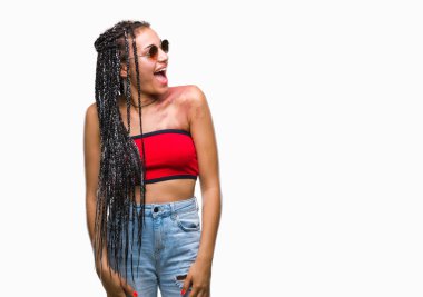 Genç örgülü saç Afrika kökenli Amerikalı Doğum ile işaretlemek giyen güneş gözlüğü izole arka plan uzak tarafına gülümseme ile yüzünde, doğal ifade inceliyorlar. Kendine güvenen gülüyor.