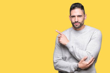 Genç yakışıklı adam giyen kazak izole üzerinden reklam, ciddi ve sakin yüz gösterilen yan el parmak ile işaret arka plan