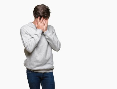 Üzgün ifade yüz eller ile ağlayarak süre kapsayan ile izole arka plan üzerinde sweatshirt giyen genç yakışıklı sportif adam. Depresyon kavramı.