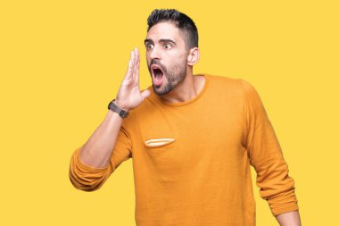 Yakışıklı delikanlı bağırarak ve ağzı üzerinde el ile yan için çığlık izole arka plan üzerinde. İletişim kavramı.