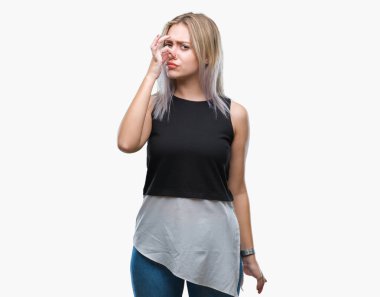 Sarışın genç kadın bir şey pis ve iğrenç kokulu izole arka plan, dayanılmaz koku, holding nefes burun parmaklar ile. Kötü kokuyor kavramı.