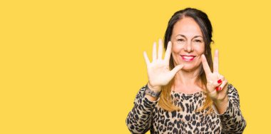 Güzel orta yaş kadın giyiyor leopar hayvan Yazdır elbise gösterme ve işaret yukarıya parmak yedinci ile gülümseyen ise kendinden emin ve mutlu.