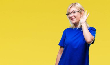 Bir işitme söylenti ya da dedikodu için dinleme kulak üzerinde el ile gülümseyen izole arka plan üzerinde gözlük takan genç güzel sarışın kadın. Sağırlık kavramı.