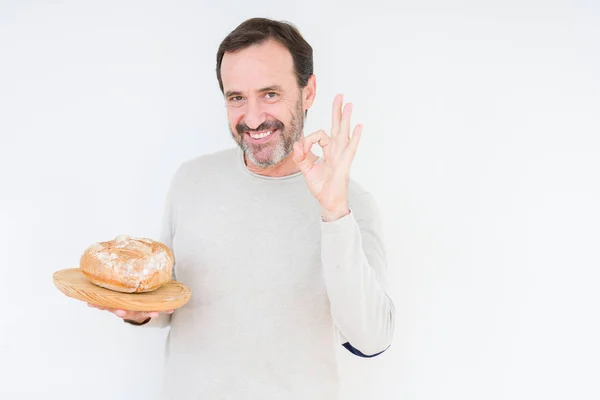 Senior Man Bedrijf Zelfgemaakte Verse Brood Geïsoleerde Achtergrond Doen Teken — Stockfoto